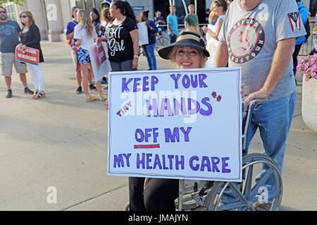 Youngstown, Ohio, USA. 25. Juli 2017. Rollstuhl gebundenen Demonstrant demonstriert gegen Trumpcare Streetside bei einem Besuch in der Stadt von Präsident Trump. Bildnachweis: Mark Kanning/Alamy Live-Nachrichten Stockfoto