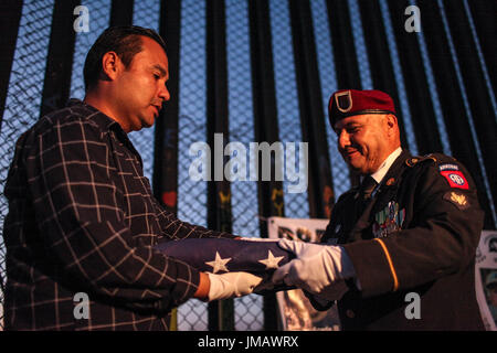 Tijuana, Baja California, Mexiko. 4. Juli 2017. EDWIN SALGADO (L) Deportierten U.S. Marine Corps Veteran und ein HECTOR BARAJAS-VARELA (R), ein Deportierten US Army Veteran, Falten Sie eine amerikanische Flagge während ein 4. Juli Feier entlang der US-mexikanischen Grenze in Tijuana, Baja California, Mexiko. Bildnachweis: Joel Angel Juarez/ZUMA Draht/Alamy Live-Nachrichten Stockfoto