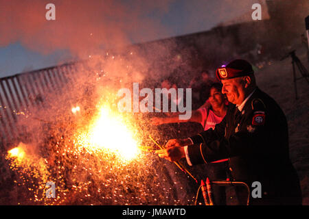 Tijuana, Baja California, Mexiko. 4. Juli 2017. HECTOR BARAJAS-VARELA, ein Deportierten US Army Veteran, zündet Feuerwerk während ein 4. Juli Feier entlang der US-mexikanischen Grenze in Tijuana, Baja California, Mexiko. Bildnachweis: Joel Angel Juarez/ZUMA Draht/Alamy Live-Nachrichten Stockfoto