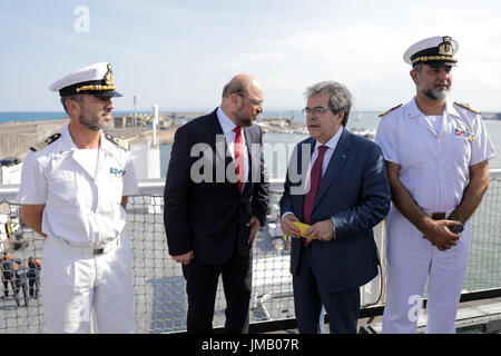 Catania, Italien. 27. Juli 2017. SPD Kanzler Kandidaten und Partei-Chef Martin Schulz (C L) und Bürgermeister von Catania Enzo Bianco (C R) eine italienische Küstenwache Schiff in den Hafen besuchen, wo Flüchtlinge in der mediterranen Ankunft in Catania, Italien, 27. Juli 2017 gerettet. Foto: Kay Nietfeld/Dpa/Alamy Live News Stockfoto