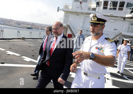 Catania, Italien. 27. Juli 2017. SPD-Kanzlerkandidat und Parteivorsitzende Martin Schulz (C) und Bürgermeister von Catania Enzo Bianco (L) besuchen eine italienische Küstenwache Schiff in den Hafen, wo Flüchtlinge in der mediterranen Ankunft in Catania, Italien, 27. Juli 2017 gerettet. Foto: Kay Nietfeld/Dpa/Alamy Live News Stockfoto