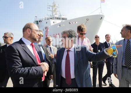 Catania, Italien. 27. Juli 2017. SPD-Kanzlerkandidat und Parteivorsitzende Martin Schulz (L) und Bürgermeister von Catania Enzo Bianco (C), besuchen Sie den Hafen, wo Flüchtlinge in der mediterranen Ankunft in Catania, Italien, 27. Juli 2017 gerettet. Foto: Kay Nietfeld/Dpa/Alamy Live News Stockfoto