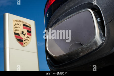 Datei - eine Datei Bild vom 4. November 2015 zeigt den Auspuff von einem Porsche Cayenne neben dem Porsche-Logo in Stuttgart, Deutschland. Foto: Christoph Schmidt/dpa Stockfoto