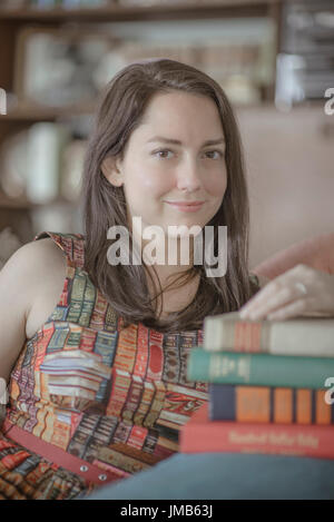 Frau mit Büchern in einem Kleid mit Büchern über es Stockfoto