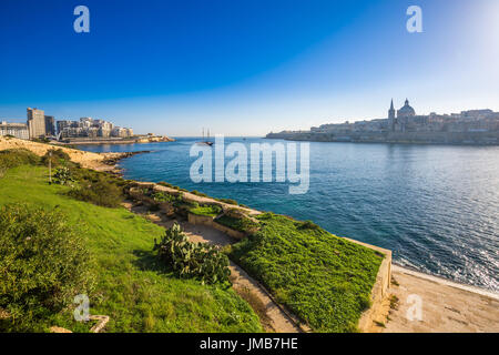 Valletta, Malta - Skyline-Blick von der alten Stadt von Valletta und Sliema bei Sonnenaufgang erschossen von Manoel Island im Frühjahr mit Segelboot, St.Paul Stockfoto