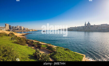 Valletta, Malta - Skyline-Blick von der alten Stadt von Valletta und Sliema bei Sonnenaufgang erschossen von Manoel Island im Frühjahr mit Segelboot, St.Paul Stockfoto