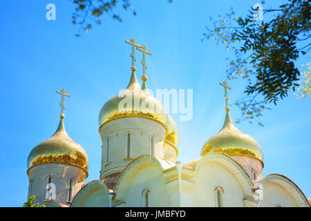 Goldene Kuppeln der orthodoxen Kirche gegen den blauen Himmel an einem sonnigen Tag. Stockfoto