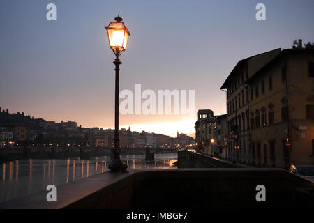 Nacht in Florenz. Glühende Vintage Straßenlaterne auf Hintergrund mit Fluss Arno Stockfoto