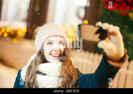 Energie-Füllung und aufregenden Winter-Wochenenden in den Bergen. Porträt der jungen Frau, die die Selfie im Freien zwischen schneebedeckten Bergen Stockfoto