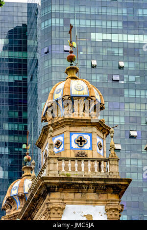 Alte Kirche in der Innenstadt von Rio De Janeiro Stadt mit neuen modernen Schwarzglas Gebäude im Hintergrund den Kontrast zwischen dem neuen und dem Stockfoto