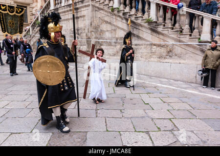 Little Boy tun Christi tragen ein Kreuz bei der Karfreitagsprozession, Ostern Feiern in der Stadt von Palermo, Sizilien, Italien Stockfoto