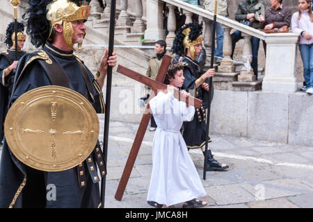 Little Boy tun Christi tragen ein Kreuz bei der Karfreitagsprozession, Ostern Feiern in der Stadt von Palermo, Sizilien, Italien Stockfoto