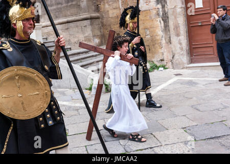 Little Boy tun Christi tragen ein Kreuz bei der Karfreitagsprozession, Ostern Feiern in der Stadt von Palermo, Sizilien, Italien Stockfoto