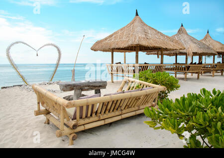 schöne senden Strand von Gili Travangan Insel mit Meerblick auf einem Hintergrund und zwei Stühlen unter Dach, Indonesien Stockfoto