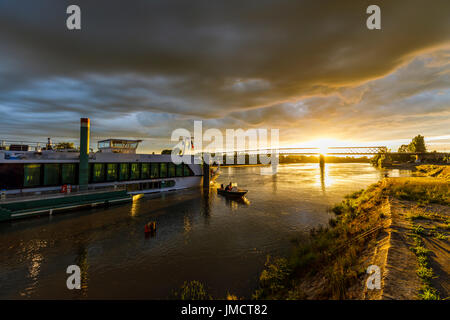 Garonne Flusslandschaft: Riverboat Amadolce, abends Sonnenuntergang hinter Brücke, Cadillac, Gironde Abteilung, Nouvelle-Aquitaine, Südwest-Frankreich Stockfoto