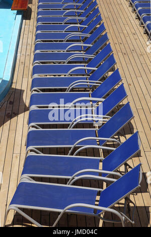 Liegestühle am Pool auf einem Kreuzfahrtschiff aufgereiht Stockfoto