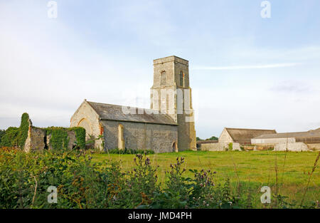 Ein Blick auf die Kirche des Hl. Johannes und die große Scheune an waxham, Norfolk, England, Vereinigtes Königreich. Stockfoto