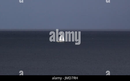 Ein kleines Segelboot aus der nordöstlichen Küste in der Nähe von Tynemouth, als Gewitterwolken Roll in. Stockfoto