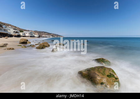 Häuser direkt am Meer mit Motion blur Wellen am Carbon Beach in Malibu, Kalifornien. Stockfoto