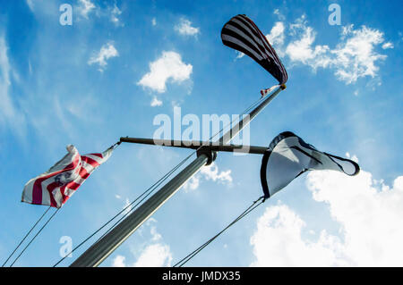 Eine Fahnenstange mit der amerikanischen Flagge, die Florida-Staatsflagge und die Marine Flagge auf einem strahlend blauen Himmel. Stockfoto