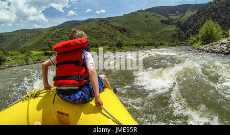 Ein kleiner Junge oder Mann reitet den Stier während einer Wildwasser River-Rafting-Expedition auf dem Colorado River im Glenwood Canyon in der Nähe von Glenwood Springs Stockfoto