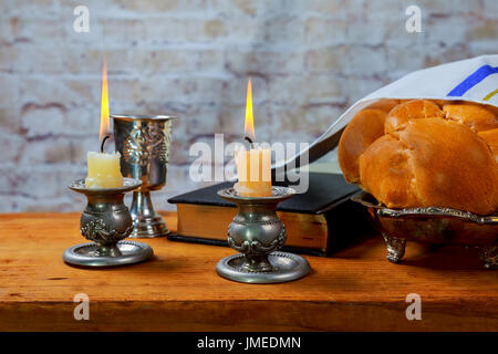 Schabbat oder Sabbat Kiddusch Zeremonie Komposition mit koscheren Wein und traditionellen süßen frischen Brotlaib Challah auf einem Vintage Holz-Hintergrund Stockfoto