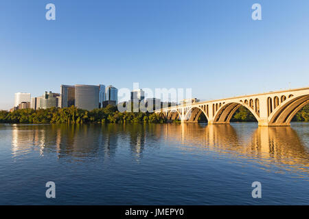 Sonnenaufgang über dem Potomac River mit Key Bridge in einer Ansicht. Die Brücke und urbanen Wolkenkratzer wie gesehen von Georgetown Park. Stockfoto