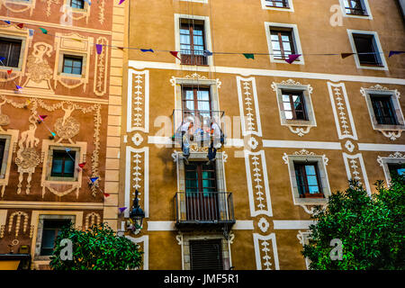 Zwei Bauarbeiter auf Seilen arbeiten auf einer Veranda an der Plaça del Pi im Gotischen Viertel von Barcelona Spanien hängen Stockfoto