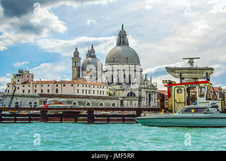 Boote und die Santa Maria Dell Salute Kathedrale von Venedig an einem teilweise bewölkten Tag, genommen aus einer Gondel auf dem Canale Grande Stockfoto