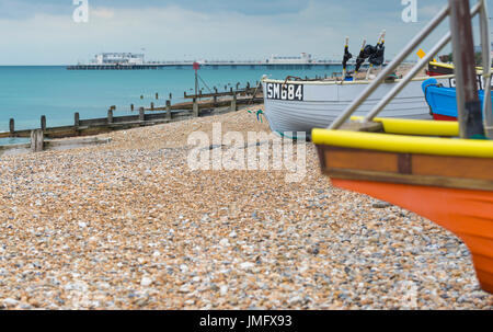 Kleine hölzerne Fischerboote auf einem Kiesstrand in Großbritannien. Stockfoto