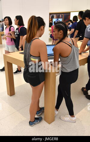 Zwei Damen untersuchen einen Laptop bei der Eröffnung der 1. Apple-Hauptquartier befindet sich im Gebäude Taipei 101, Taipei, Taiwan. Stockfoto