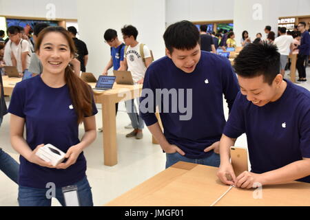 Drei Apple Mitarbeiter arbeiten fröhlich bei der Eröffnung der 1. Apple-Hauptquartier befindet sich im Gebäude Taipei 101, Taipei, Taiwan. Stockfoto