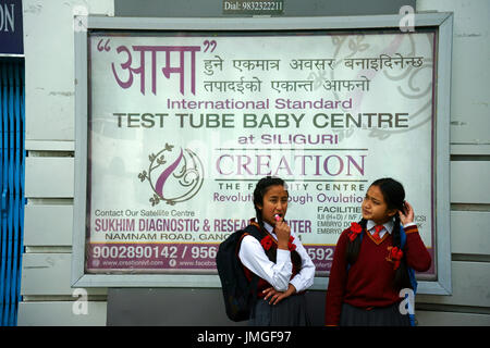 Junge Mädchen im Teenageralter Strandung vor einem Billborad Werbung Test Tube Baby Center, Stadt Gangtok, Sikkim, Indien Stockfoto