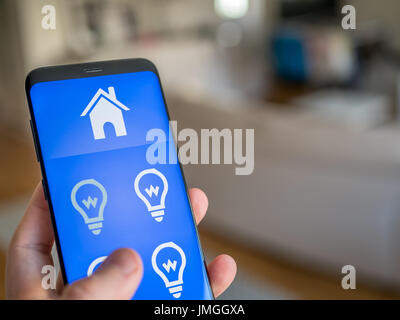Smart home-Automation, mobiles Gerät mit Licht ca. Mann nutzt sein Smartphone zu kontrollieren die Lichter im Haus. Stockfoto