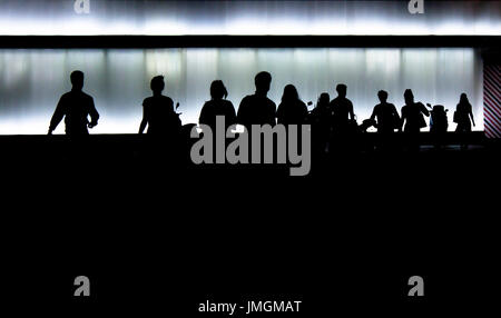 Silhouetten von jungen Menschen, die immer aus dem Gebäude Stockfoto