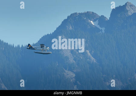 Historischen Saltspring Air de Havilland Beaver Wasserflugzeug fliegen über Remote Woodlands In British Columbia, Kanada. Stockfoto