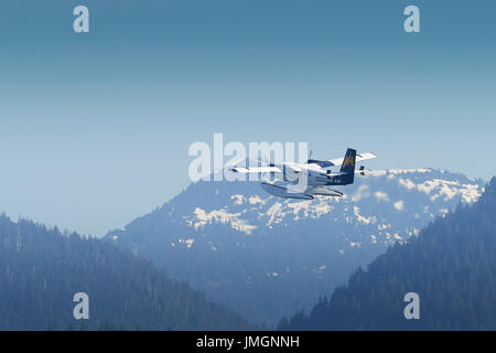 Harbour Air Services de Havilland Twin Otter Wasserflugzeug fliegen auf einen Schnee bedeckte Berg In British Columbia, Kanada. Stockfoto