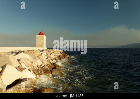 Leuchtturm im Hafen von einer kleinen Stadt an einem stürmischen Tag - Kroatien-Insel Brac Stockfoto