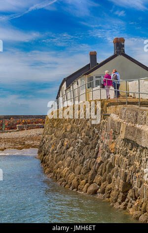 Zwei Frauen zu Fuß hinauf in Richtung Hafen Gebäude am Cobb bei Lyme Regis, Dorset im Juli - Hdr-Effekt Stockfoto