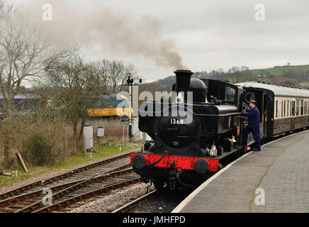 GWR-Gepäckbehälter Nr. 1369 und Beattie-Brunnenbehälter Nr. 30587 warten darauf, die Station Totnes Riverside zu verlassen, während eine Inter City 125 auf der Hauptstrecke vorbeifährt, Stockfoto