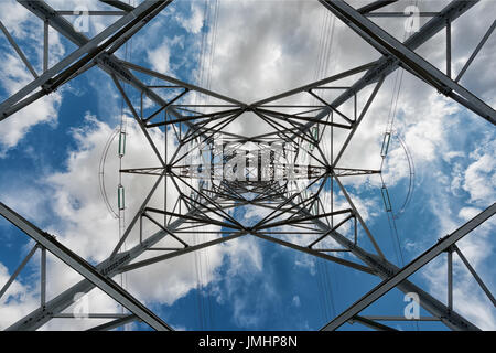 unter einer Hochspannung Pylon auf blau bewölktem Himmelshintergrund Stockfoto