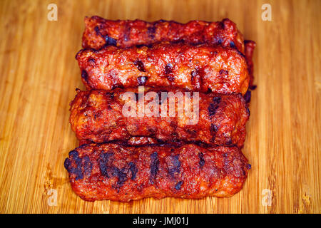 Traditionelles Essen Meat Balls "Mici" auf einem rustikalen Holztisch mit Senf Stockfoto