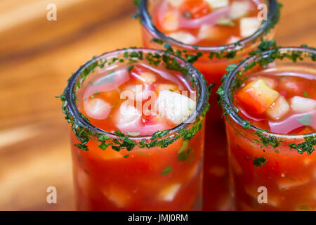Gazpacho-Sampler in hohe Schnapsgläser mit Koriander Rand als erfrischende Sommer Suppe serviert Stockfoto