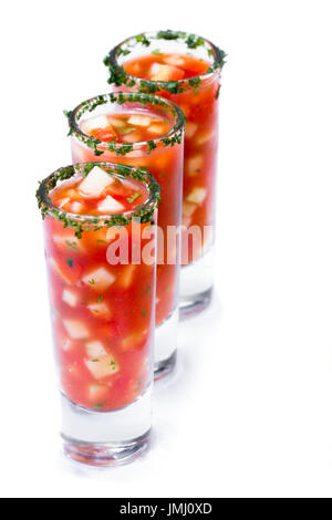 Gazpacho-Sampler serviert in hohe Schnapsgläser mit Koriander Rand isoliert auf weißem Hintergrund Stockfoto
