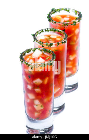 Gazpacho-Sampler serviert in hohe Schnapsgläser mit Koriander Rand isoliert auf weißem Hintergrund Stockfoto