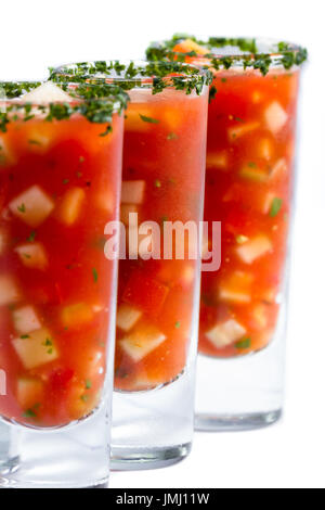 Gazpacho-Sampler serviert in hohe Schnapsgläser mit Koriander Rand isoliert auf weißem Hintergrund Stockfoto