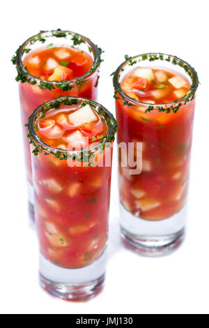 Gazpacho-Sampler serviert in hohe Schnapsgläser mit Koriander Rand isoliert auf weißem Hintergrund Stockfoto