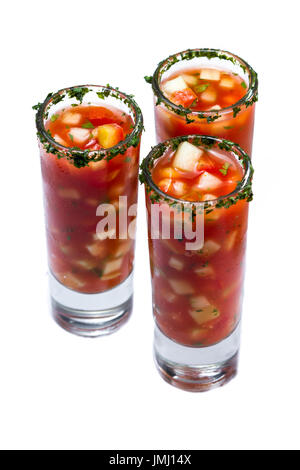 Gazpacho-Sampler serviert in hohe Schnapsgläser mit Koriander Rand isoliert auf weißem Hintergrund Stockfoto