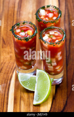 Gazpacho-Sampler in hohe Schnapsgläser mit Koriander Rand als erfrischende Sommer Suppe serviert Stockfoto