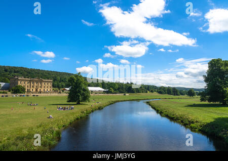 Touristen am Ufer des Flusses Derwent im Sommer in Chatsworth House, Derbyshire Stockfoto